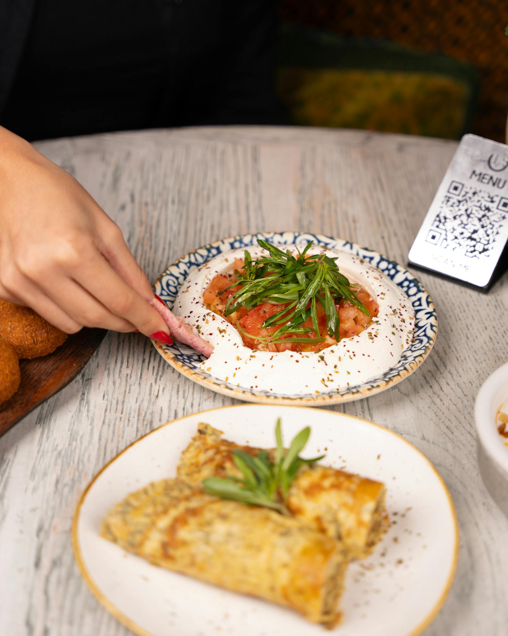 A delectable blend of Middle Eastern dishes featuring hummus and crepes on a rustic table.