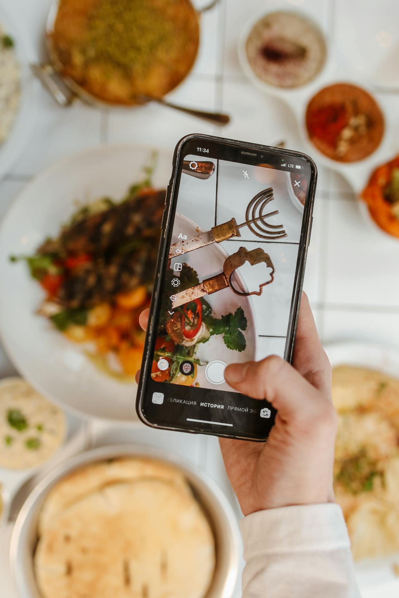 A hand captures a colorful meal on a smartphone, showcasing modern food photography.