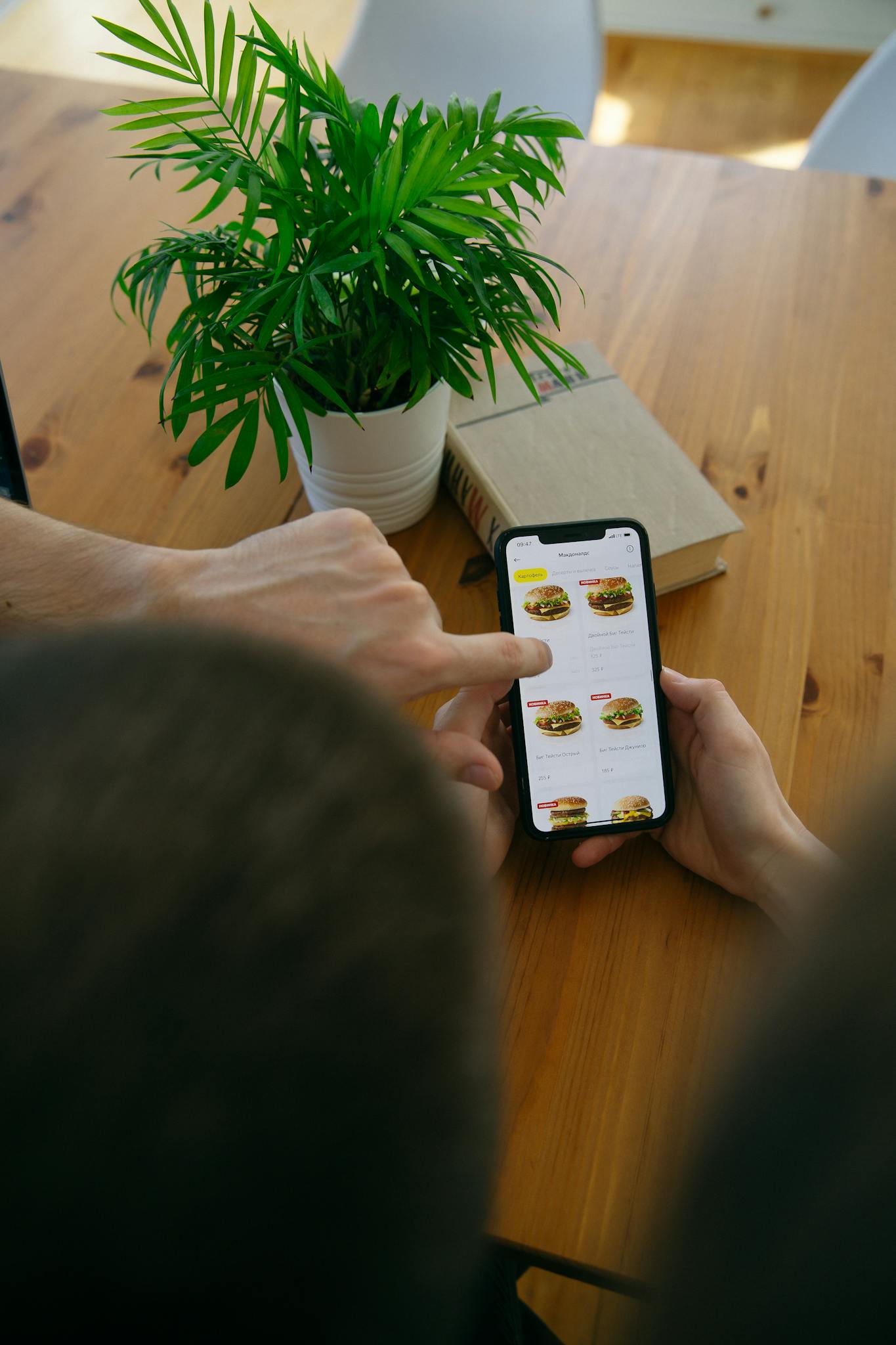 A person using a smartphone to browse an online food menu indoors.